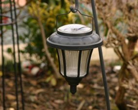 A solar lamp hanging in a garden.